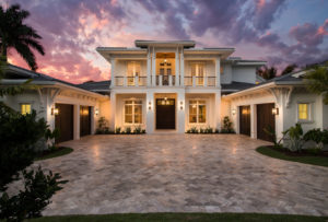 Image of front elevation at dusk of a 2-story 4 bedroom 5,464sf house plan